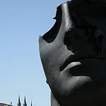 This big bronze sculpture is made by the artist Igor Mitoraj. He combines antique heads, torsos and characters of the ancient world with modernity in a deliberately violating way.