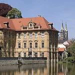 Already three years after finishing the Böttingerhaus, Ignaz Böttinger had the baroque Moated Castle Concordia built between 1716-1722 by the architect Johann Dientzenhofer. The building hosts the International House of Artists Villa Concordia nowadays. You will have the nicest view from the opposite riverbank, the Mühlwörth.