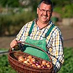 Gärtner Michael Niedermaier mit einem Korb Zwiebeln von der Gärtnerei Sebastian Niedermaier