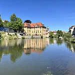 Das Künstlerhaus Villa Concordia spiegelt sich im Wasser der Regnitz.