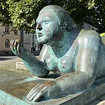 Von den Bambergern liebevoll „Dicke Frau“ oder „Blunnzn“ genannt, ist die Skulptur „Liegende mit Frucht“ des kolumbianischen Künstlers Fernando Botero ein markantes Kunstwerk in Bamberg.