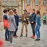 Eine Stadtführungs-Gruppe steht vor dem Alten Rathaus in Bamberg.
