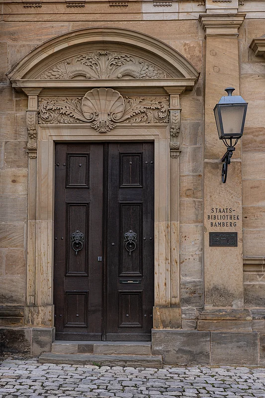 Staatsbibliothek Bamberg Die Staatsbibliothek Bamberg befindet sich im linken Gebäudeflügel der Neuen Residenz und beherbergt beeindruckende Buchschätze aus den vergangenen Jahrhunderten.