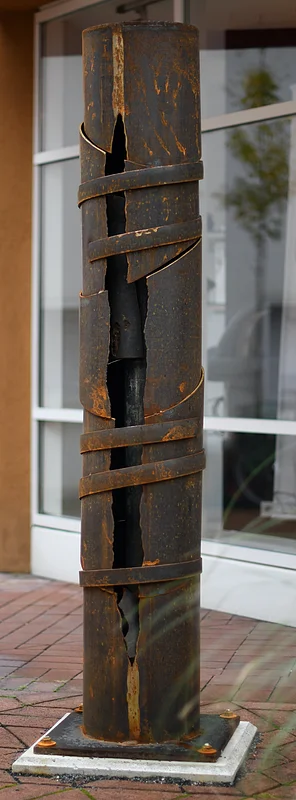 Die Skulptur von Bernd Wagenhäuser in den Theatergassen besteht aus einer Gusseisensäule aus einer ehemailien Nähseidenfarbik, die er mit Cor-Ten-Stahl ummantel hat.