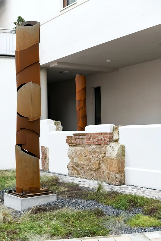 Drei Skulpturen von Bernd Wagenhäuser stehen im Quartier an den Stadtmauern. Sie bestehen aus Gusseisensäulen aus einer ehemailien Nähseidenfarbik, die der Künstler mit Cor-Ten-Stahl ummantel hat.