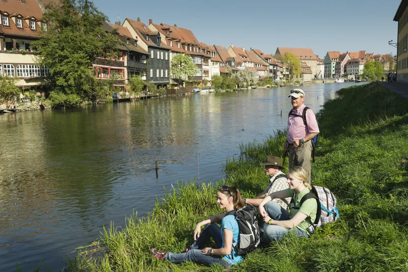 Klein Venedig Bamberg Wanderer machen Rast auf einer Wiese mit Blick auf Klein Venedig.