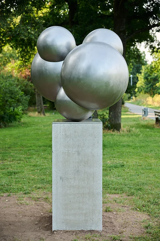 Skulptur Wassermoleküle The stainless steel figure by the Nuremberg artist Michaela Briet has been standing on the banks of the Adenauer in Bamberg since 2024 and is part of the “Art Encounters on the Canal” project of the Regnitz Cycle Path canal route.