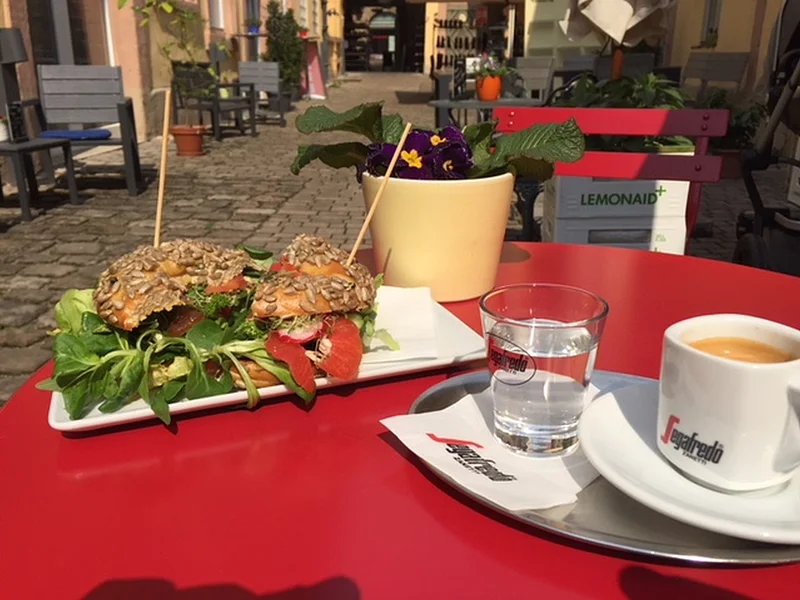 Foto eines Bagels mit Kaffee, der im Cafe Leander Bamberg serviert wird.