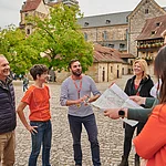 Eine Stadtführungsgruppe  steht in der Alten Hofhaltung. Im hinergrund sieht man den Dom.